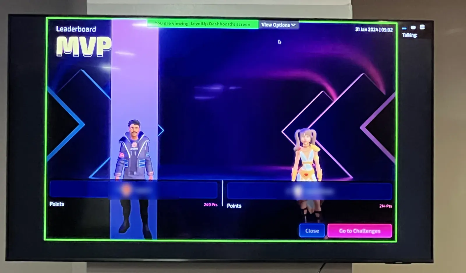 LevelUp MVP leaderboard with two 3D avatars on an office screen